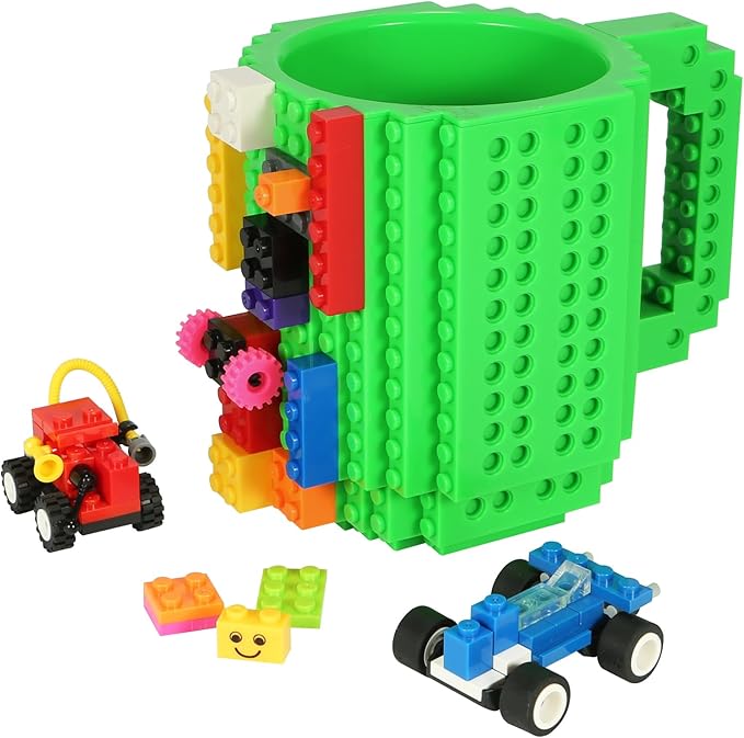 Grüne Kaffeetasse mit Noppen und bunten Bausteinen samt kleiner Spielzeugautos