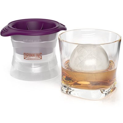 Lila Silikon-Eiskugelform neben Whiskyglas mit runder Eiskugel