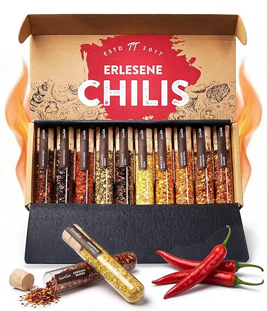 Geschenkset mit zehn Chilisorten in Reagenzgläsern und frischen roten Chilischoten