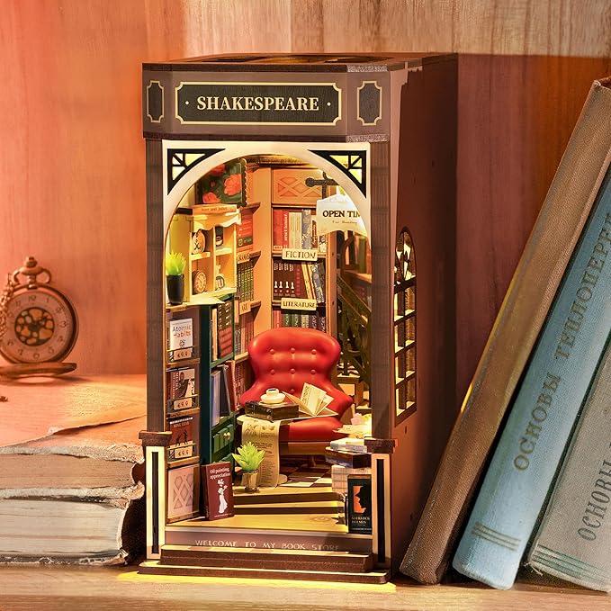 Miniatur-Booknook als beleuchtete Shakespeare-Buchhandlung mit rotem Sessel zwischen Büchern